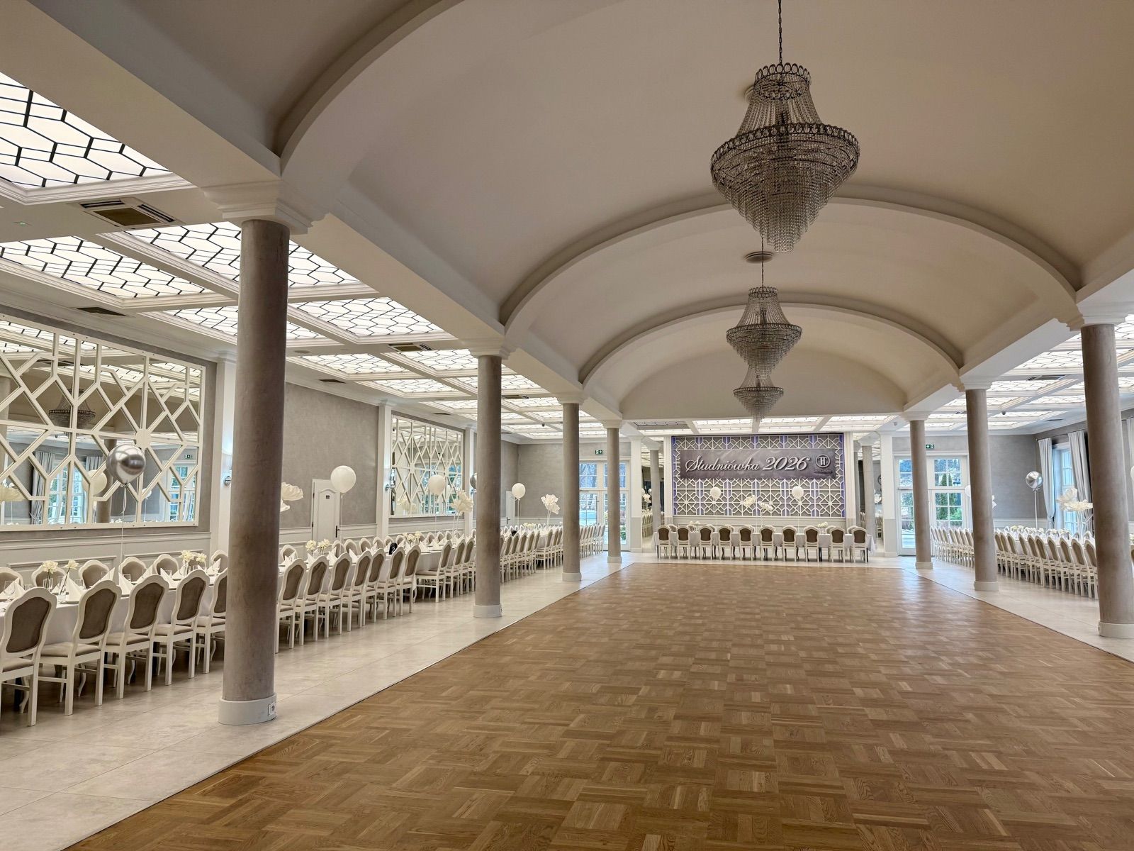 Duża sala przyjęć z nakrytymi stołami dla stu gości