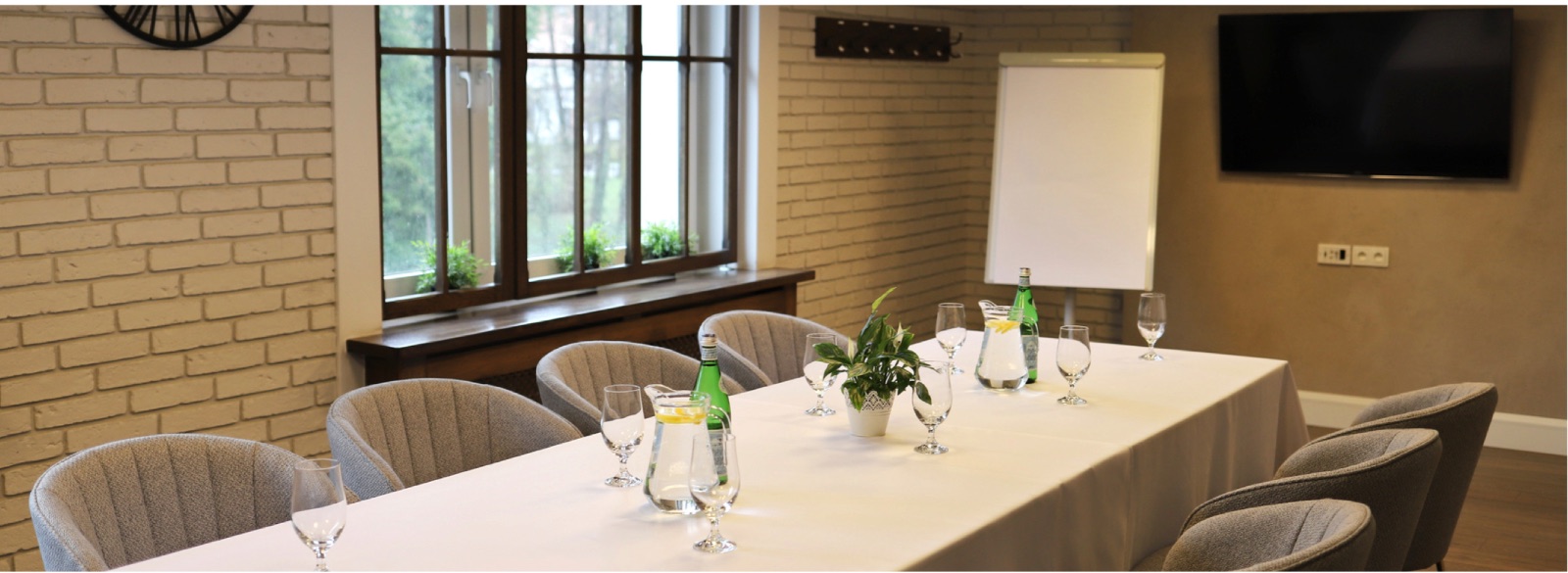 Ein intimer Tagungsraum mit Ziegel, TV und Flipchart - Hotel Toscania